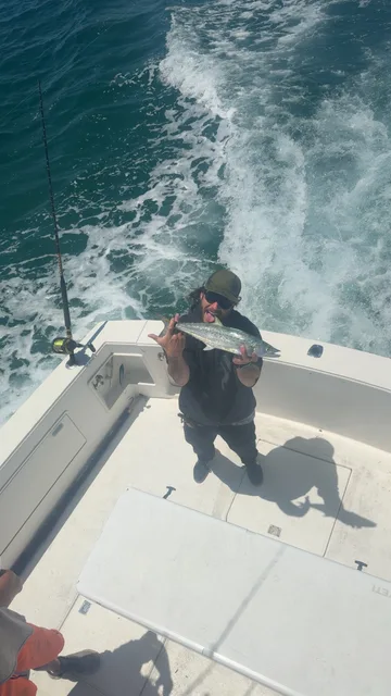 Angler showing off a freshly caught Spanish mackerel aboard an East Pass Excursions Destin sportfishing charter