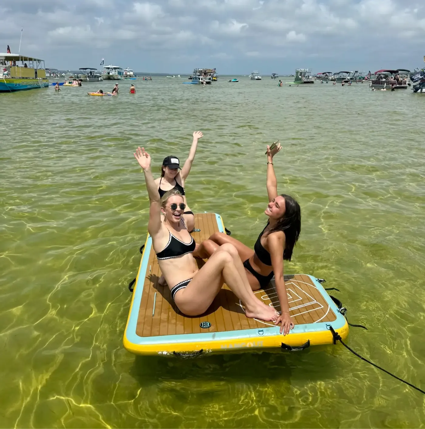 Guests lounging on floating paddleboards off a Crab Island charter