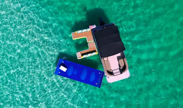 Aerial of boats anchored on the shallow, turquoise Crab Island sandbar just inside the East Pass in Destin