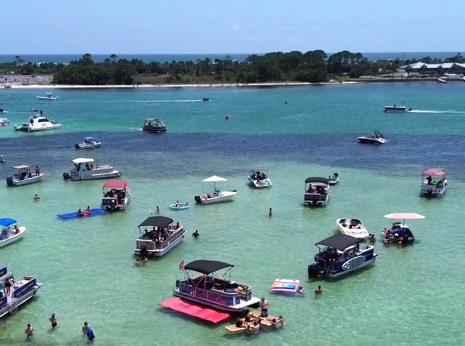 Aerial of the busy Crab Island sandbar dotted with anchored charter boats near Destin