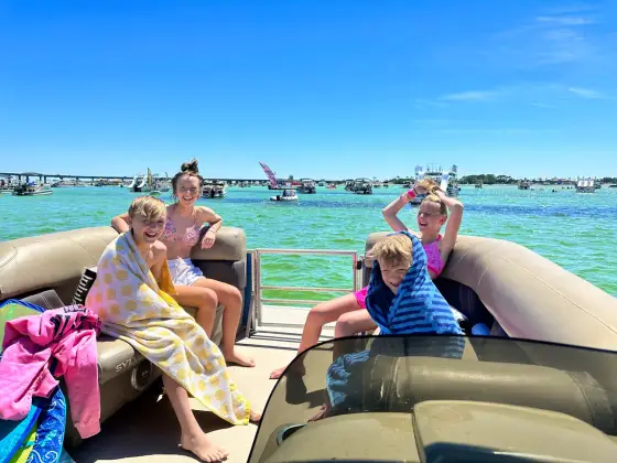Kids wrapped in towels enjoying a private pontoon charter at Crab Island