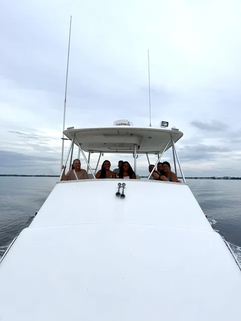 A family smiling together from the tower of a charter boat cruising Destin's calm waters