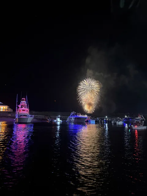 Fireworks bursting over the Destin Harbor full of charter boats at night