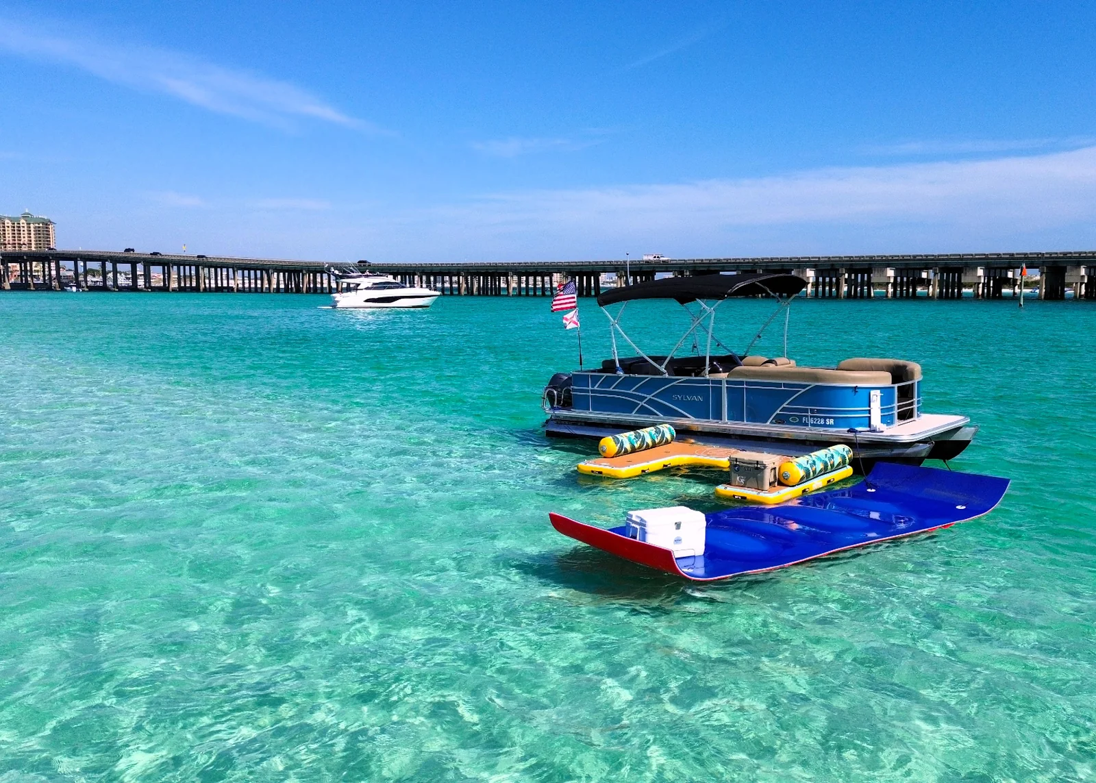 A pontoon boat passing beneath a bridge near the East Pass in Destin