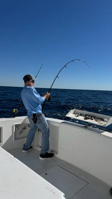 Angler fighting a fish on the line aboard an East Pass Excursions Destin sportfishing charter