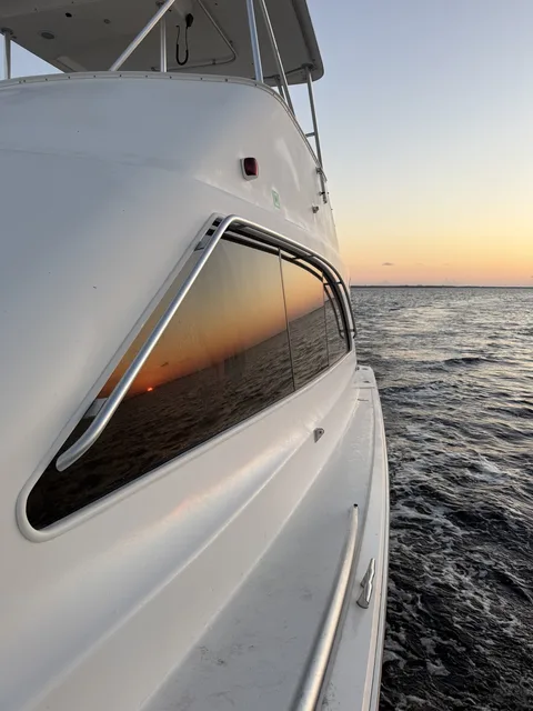 A vivid sunset reflected in the cabin window of a Destin charter boat heading back to harbor